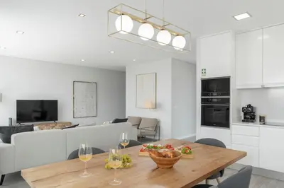 a kitchen and living room with a table and wine glasses at Vila Chu by An Island Apart in Ponta do Sol
