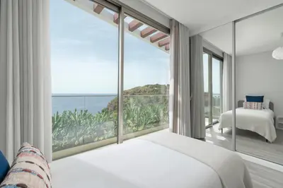a bedroom with a large window with a view of the ocean at Vila Chu by An Island Apart in Ponta do Sol