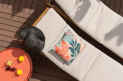 a white couch with a pillow and a hat next to a table at Vila Chu by An Island Apart in Ponta do Sol