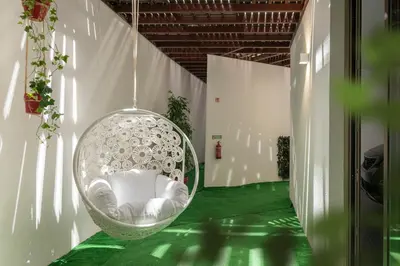 a room with a hanging chair on a green floor at Vila Chu by An Island Apart in Ponta do Sol
