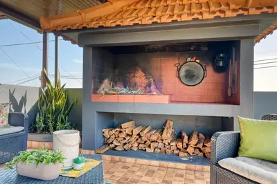 a patio with a fireplace with chairs and a table at Casa Primavera, a Home in Madeira in Ponta do Sol