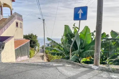 a blue street sign on the side of a road at Casa Primavera, a Home in Madeira in Ponta do Sol