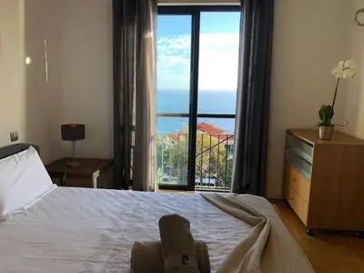 a bedroom with a bed with a view of the ocean at Forum Ocean View Apartment in Funchal