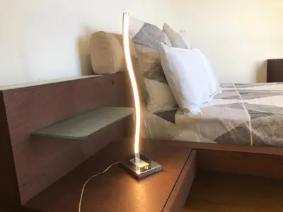 a lamp sitting on a table next to a bed at Forum Ocean View Apartment in Funchal