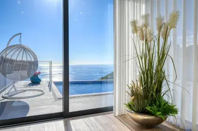 a room with a window with a view of the ocean at Quinta do Feliz, a Home in Madeira in Ponta do Sol