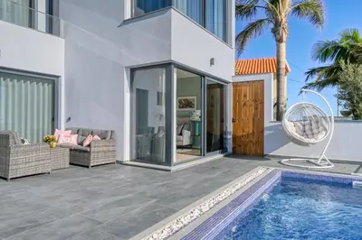 a house with a swimming pool and a patio at Quinta do Feliz, a Home in Madeira in Ponta do Sol