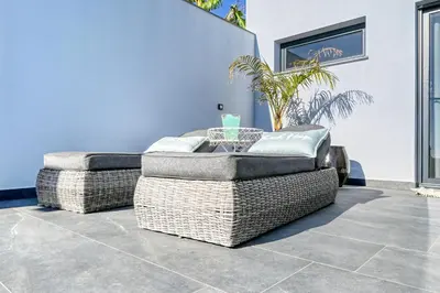 two wicker chairs sitting on a patio at Quinta do Feliz, a Home in Madeira in Ponta do Sol