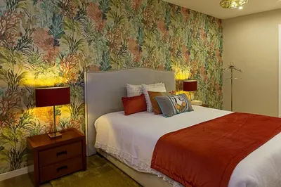 a bedroom with a bed with a floral wallpaper at Quinta do Feliz, a Home in Madeira in Ponta do Sol