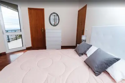 a large white bedroom with a large bed with two pillows at 2 Bedroom Apartment in Calheta in Arco da Calheta