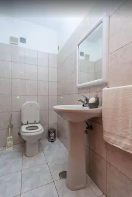 a bathroom with a toilet and a sink and a mirror at 2 Bedroom Apartment in Calheta in Arco da Calheta