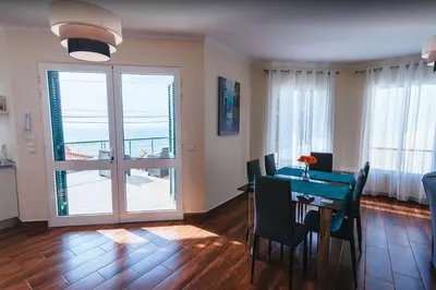 a dining room with a table and a view of the ocean at 2 Bedroom Apartment in Calheta in Arco da Calheta