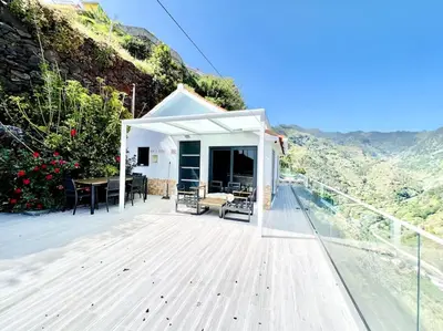 a white house with a deck with a view at Mar a Vista by Your Madeira Rentals in Ponta do Sol