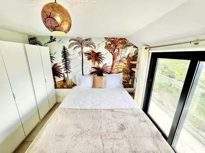 a bedroom with a bed with a mural of palm trees at Mar a Vista by Your Madeira Rentals in Ponta do Sol