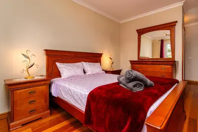 a bedroom with a bed with a red blanket and a mirror at Katerina´s Place - Funchal in Funchal