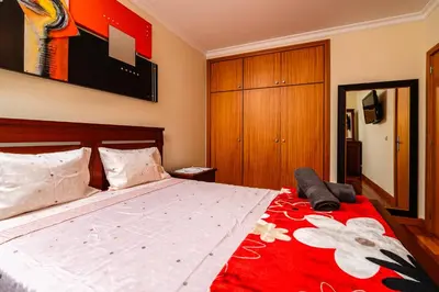 a bedroom with a large bed with a red blanket at Katerina´s Place - Funchal in Funchal