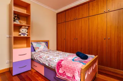 a small bedroom with a bed and wooden cabinets at Katerina´s Place - Funchal in Funchal