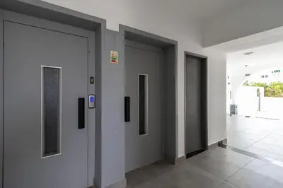 a hallway with four doors in a building at 3 Minutes TO THE BEACH, 2 BEDROOM AMAZING APT WITH BALCONY, BBQ GRILL AND POOL in Sagres