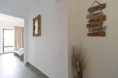 a room with a wall with a sign on the wall at 3 Minutes TO THE BEACH, 2 BEDROOM AMAZING APT WITH BALCONY, BBQ GRILL AND POOL in Sagres