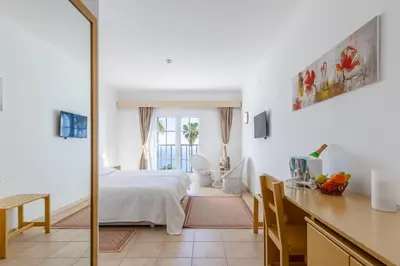 a bedroom with a bed and a table and a desk at Quinta Alegre in Calheta