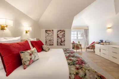 a bedroom with a large white bed with red pillows at Quinta Alegre in Calheta