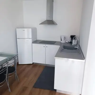 a kitchen with a sink and a refrigerator and a table at Casa Bela Vista Studio 2 in Ribeira Brava