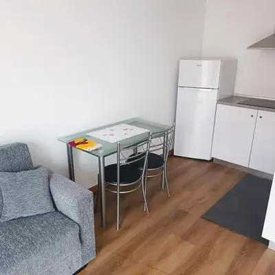 a living room with a table and a couch and a refrigerator at Casa Bela Vista Studio 2 in Ribeira Brava