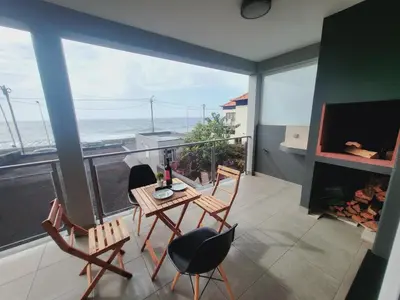 a balcony with a table and chairs and a view of the ocean at Casa Marcelino Refugio Frente Mar in Paul do Mar
