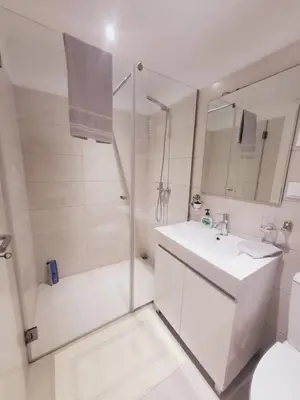 a white bathroom with a shower and a sink at Casa Marcelino Refugio Frente Mar in Paul do Mar