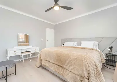 a white bedroom with a bed and a ceiling fan at Better Together Funchal I in Funchal