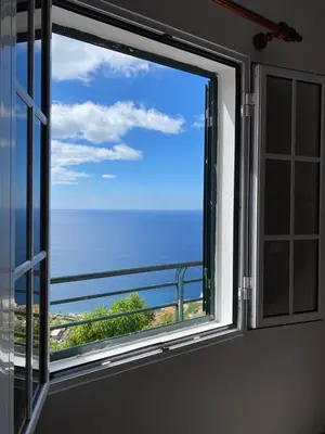 a window with a view of the ocean at Pana House in Calheta