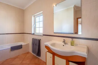 a bathroom with a sink and a mirror and a tub at Porto de Mos 86 by Destination Algarve in Lagos