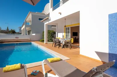 a villa with a swimming pool and a dining area at Porto de Mos 86 by Destination Algarve in Lagos