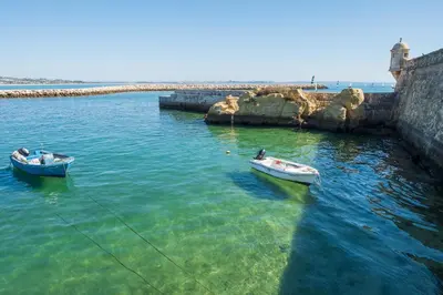 two boats in the water next to a pier at Porto de Mos 86 by Destination Algarve in Lagos