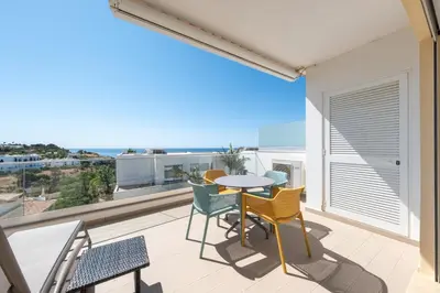 a balcony with a table and chairs and a view of the ocean at Porto de Mos 69 by Destination Algarve in Lagos