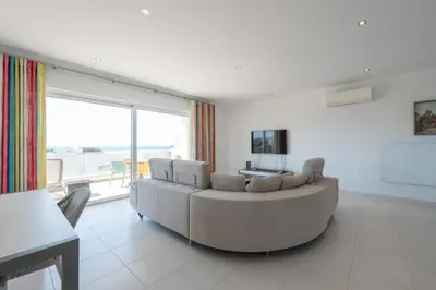 a living room with a couch and a large window at Porto de Mos 69 by Destination Algarve in Lagos