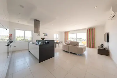 a large living room with a couch and a kitchen at Porto de Mos 69 by Destination Algarve in Lagos