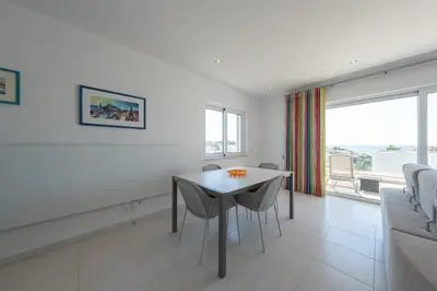 a white living room with a table and chairs at Porto de Mos 69 by Destination Algarve in Lagos