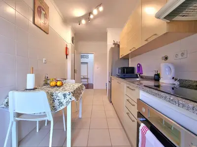 a kitchen with a table and a counter top at Junto ao Mar - Apartamento T1 in Santa Cruz