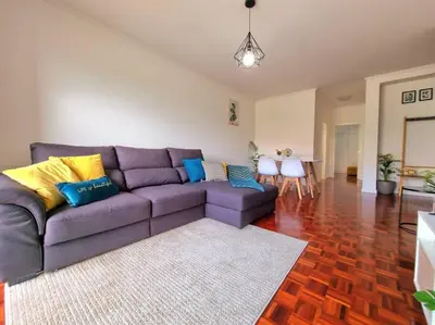 a living room with a purple couch and a table at Junto ao Mar - Apartamento T1 in Santa Cruz