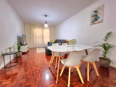 a living room with a white table and chairs at Junto ao Mar - Apartamento T1 in Santa Cruz