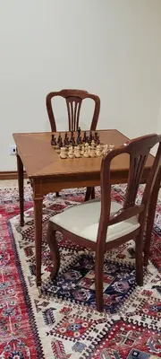 a wooden chess board and two chairs sitting around a table at Theo's City House in Funchal