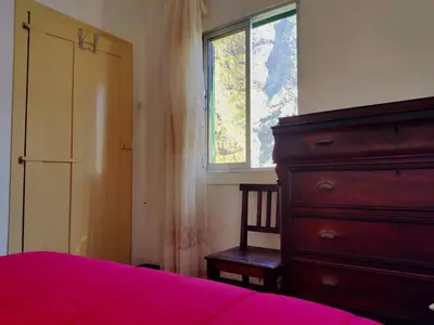 a bedroom with a bed and a dresser and a window at Casa da Avo Rosa in São Vicente