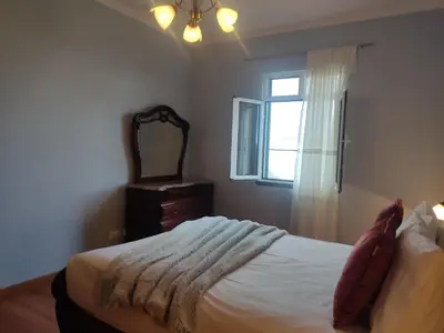 a bedroom with a bed with a mirror and a window at Brisas do Atlántico in Porto Moniz