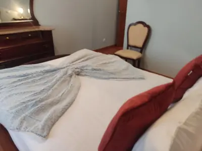 a bedroom with a bed with a dresser and a chair at Brisas do Atlántico in Porto Moniz