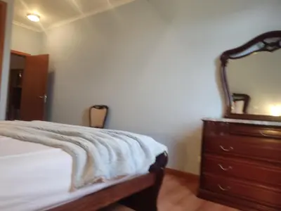 a bedroom with a bed and a dresser with a mirror at Brisas do Atlántico in Porto Moniz