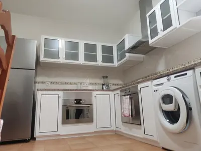 a kitchen with white cabinets and a washer and dryer at Brisas do Atlántico in Porto Moniz