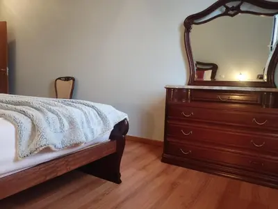 a bedroom with a bed and a dresser with a mirror at Brisas do Atlántico in Porto Moniz