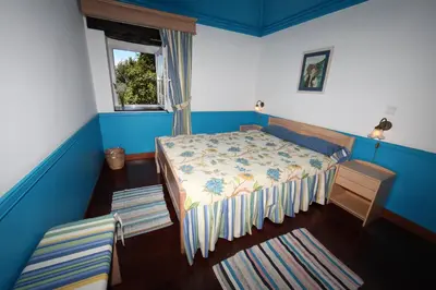 a small bedroom with a bed and a window at Casa do Ribeirinho in Porto Moniz