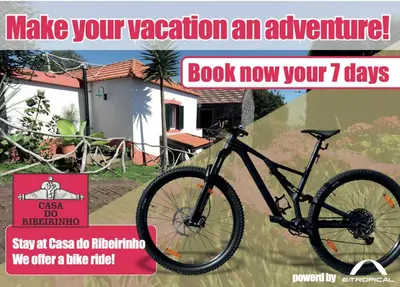 a black bike parked in front of a house at Casa do Ribeirinho in Porto Moniz