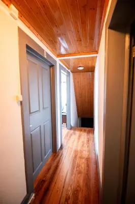 an empty hallway with a door and wooden floors at Casa das Vistas in Porto Moniz